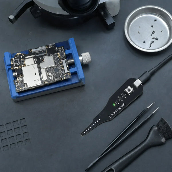 CircuitSense probe on an anti-static mat next to a smartphone motherboard and tweezers