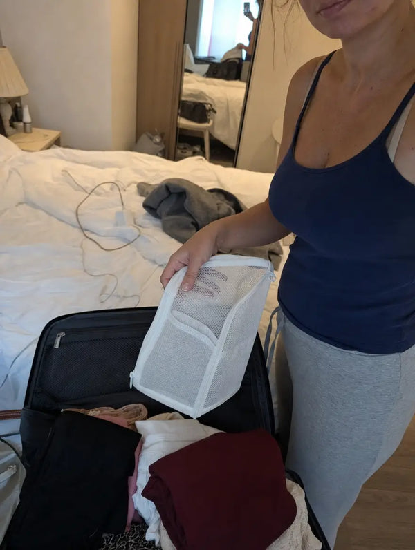 Traveler packing a folded TravelPouch into a suitcase