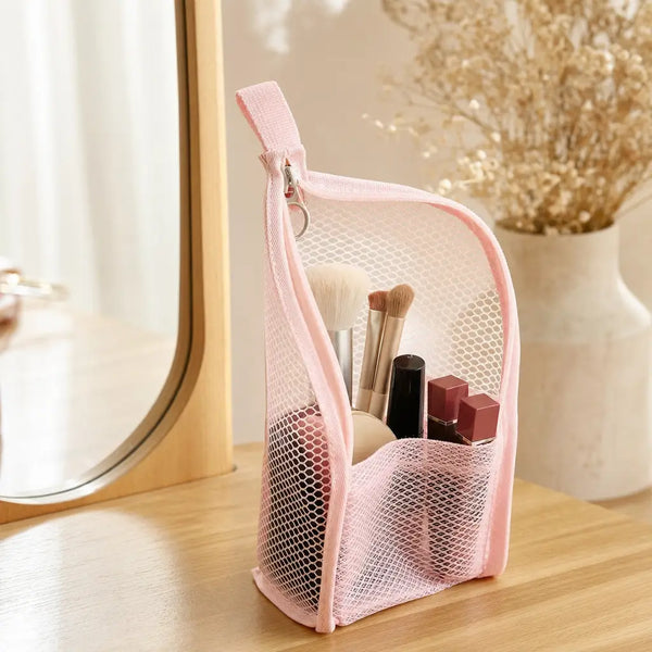 Pink TravelPouch holding makeup brushes and lipsticks