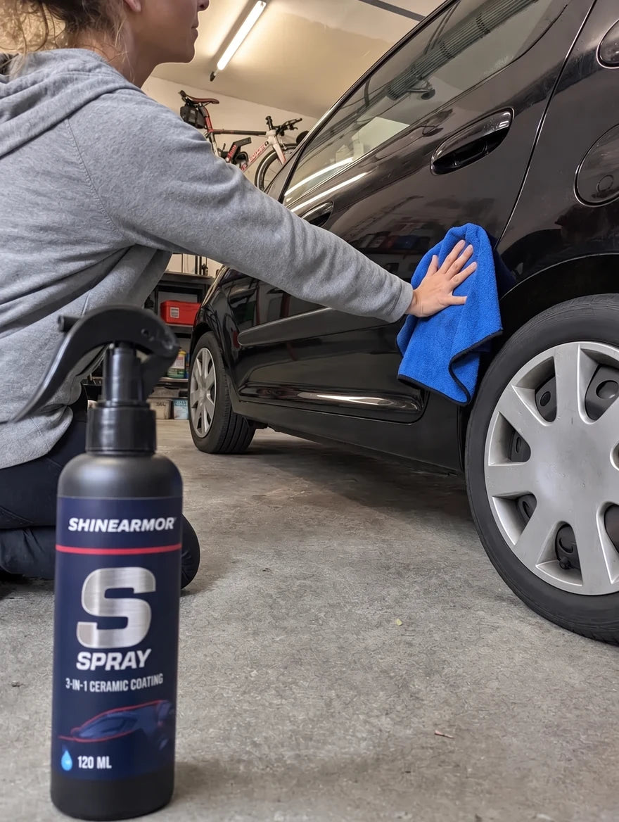 Customer photo: applying ShineArmor to a black car in a garage