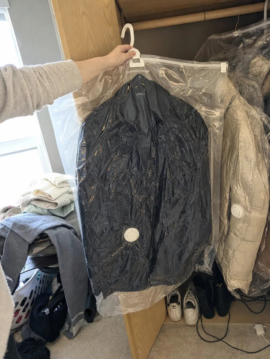 Customer photo: two SupremeStorage bags shrunk onto coats in a bedroom closet